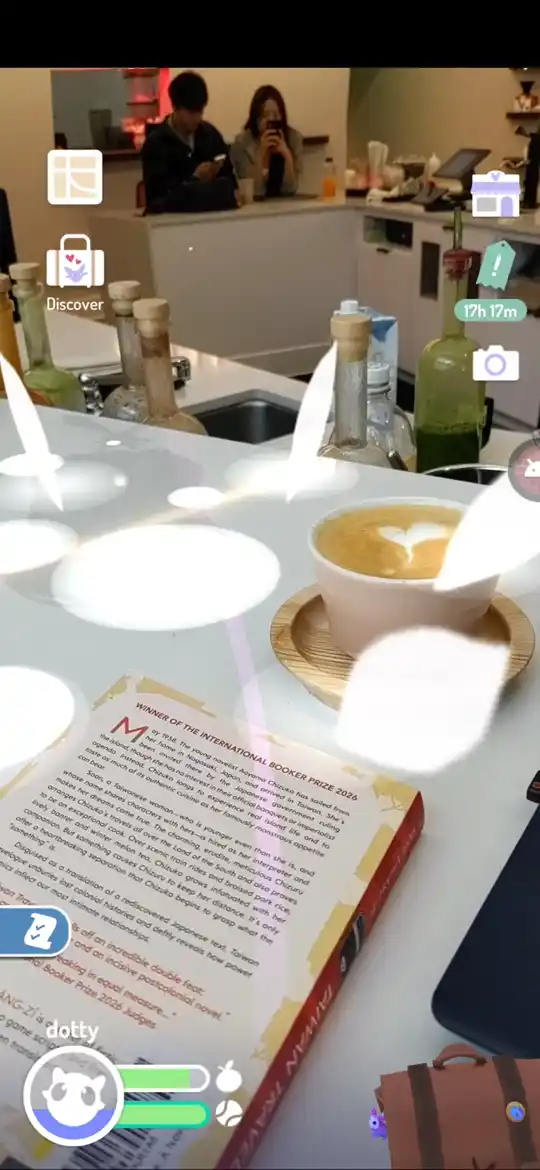 The pet standing on a cafe counter beside a latte and an open book