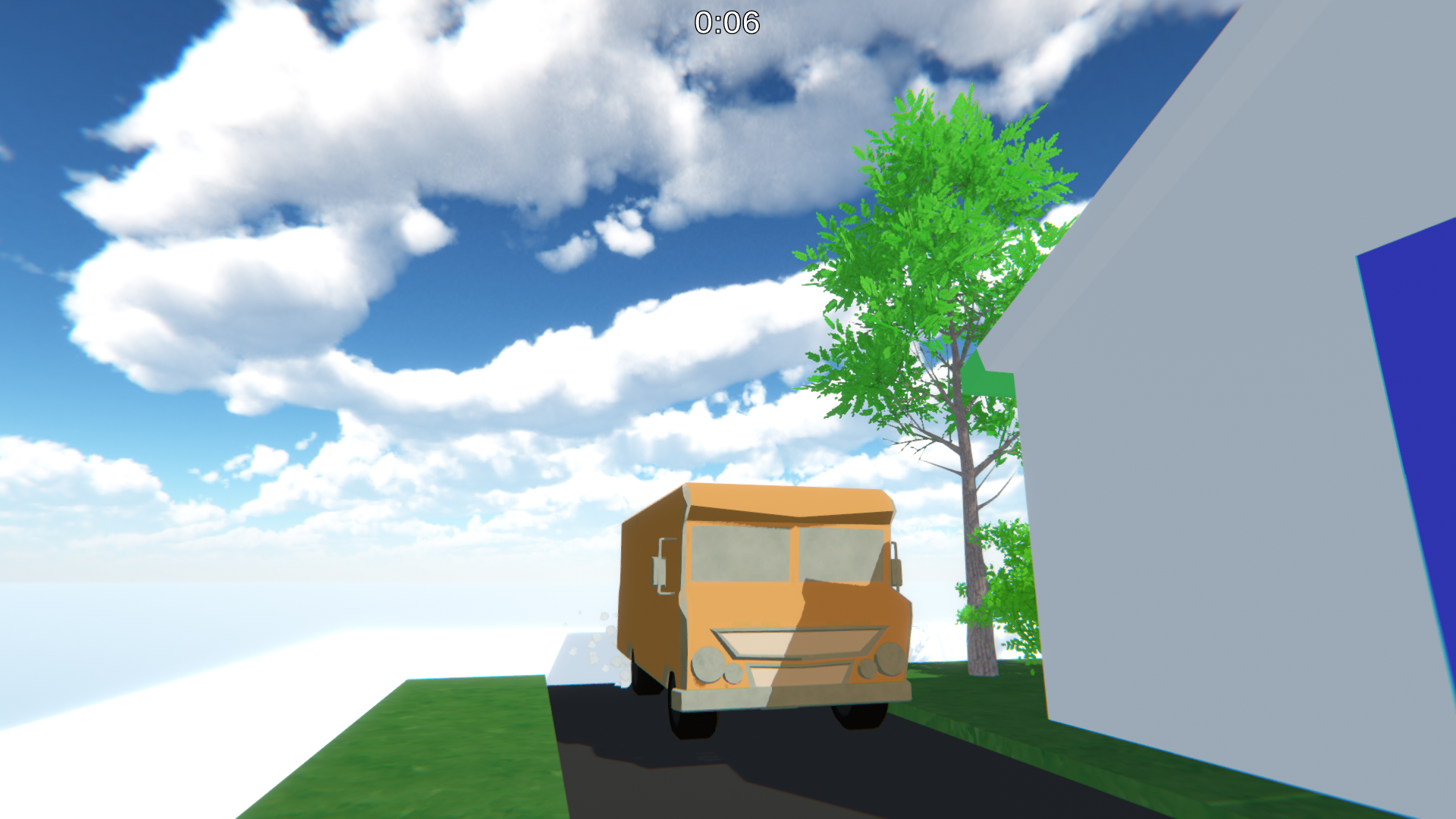 The RV driving down a road past a tree and a building under a bright, cloudy sky